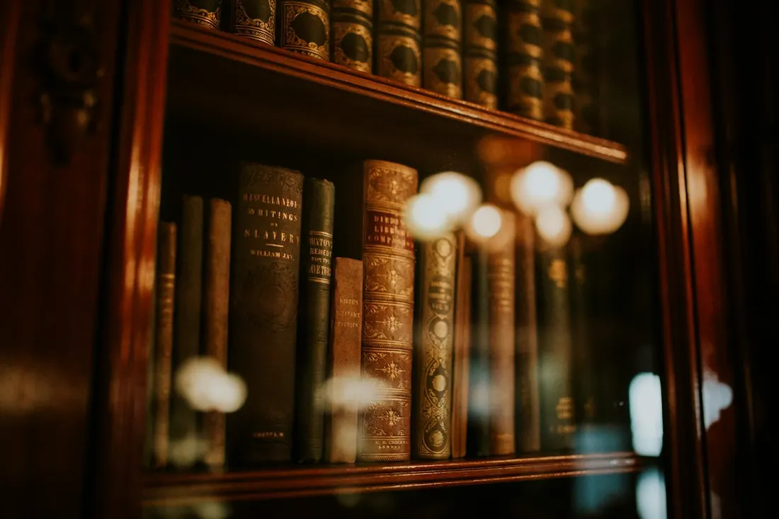 Biblioteca de madera con libros jurídicos antiguos encuadernados